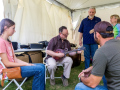 Jesse Brock sets up Emma M's new mandolin backstage at Wylie Jubilee 2025