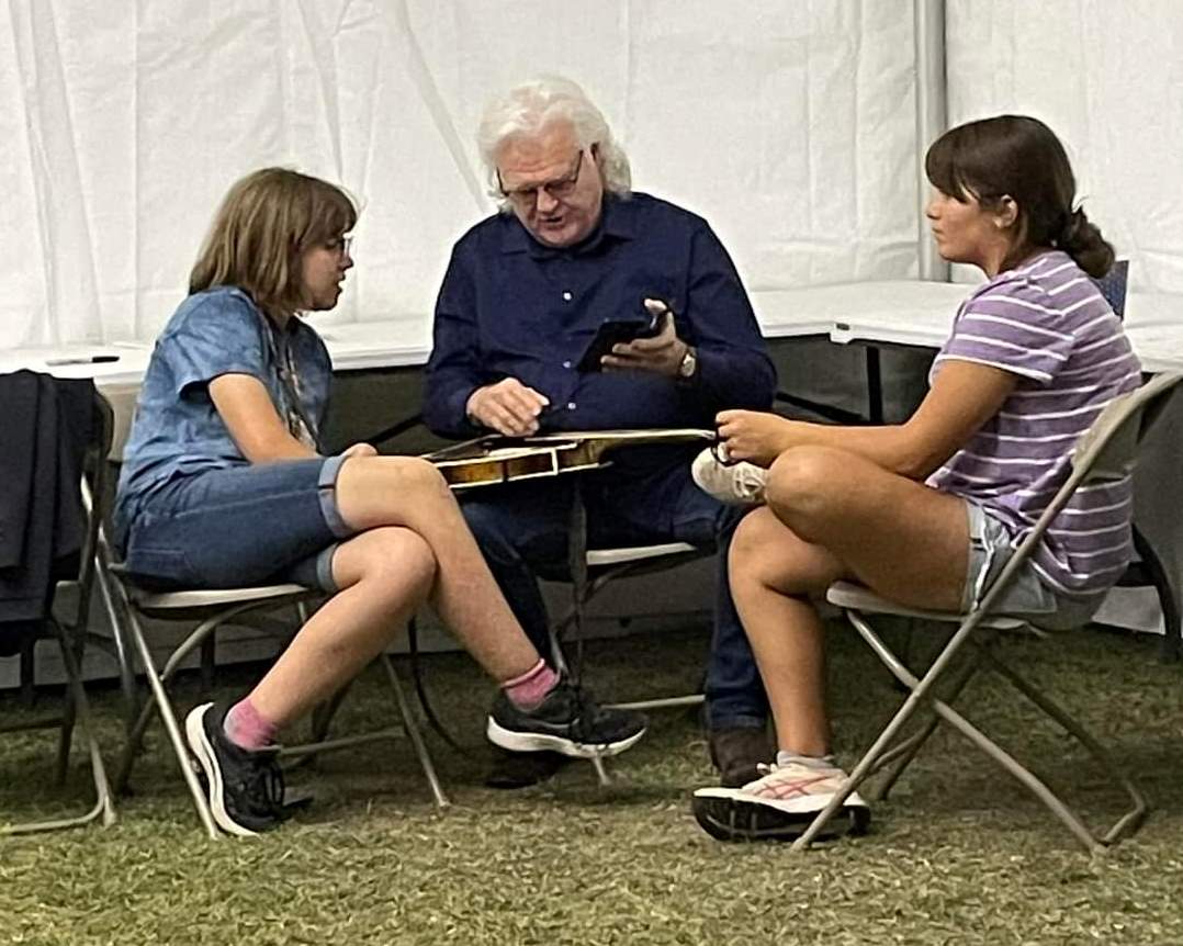 Ricky explains mandolin tuning at Bloomin\' 2023; Adelaide asks \"is he really famous?\" (Angie Logan)