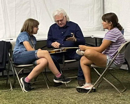 Ricky explains mandolin tuning at Bloomin' 2023; Adelaide asks "is he really famous?" (Angie Logan)